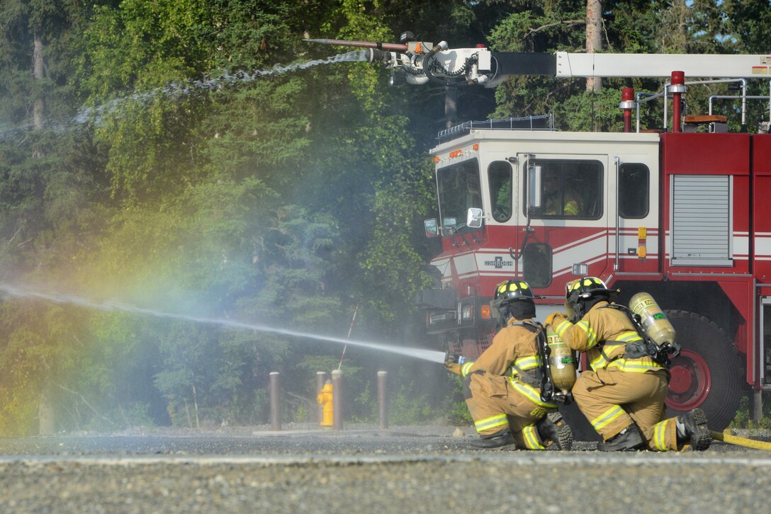 673d Civil Engineer Squadron firefighters extinguish a fire caused by a notional aircraft crash during Mission Assurance Exercise 16-7 at Joint Base Elmendorf-Richardson, Alaska, July 15, 2016. JBER simulated an aircraft crash to test the base’s ability to operate, coordinate and recover in an efficient and timely manner. (U.S. Air Force photo by Airman 1st Class Christopher R. Morales)