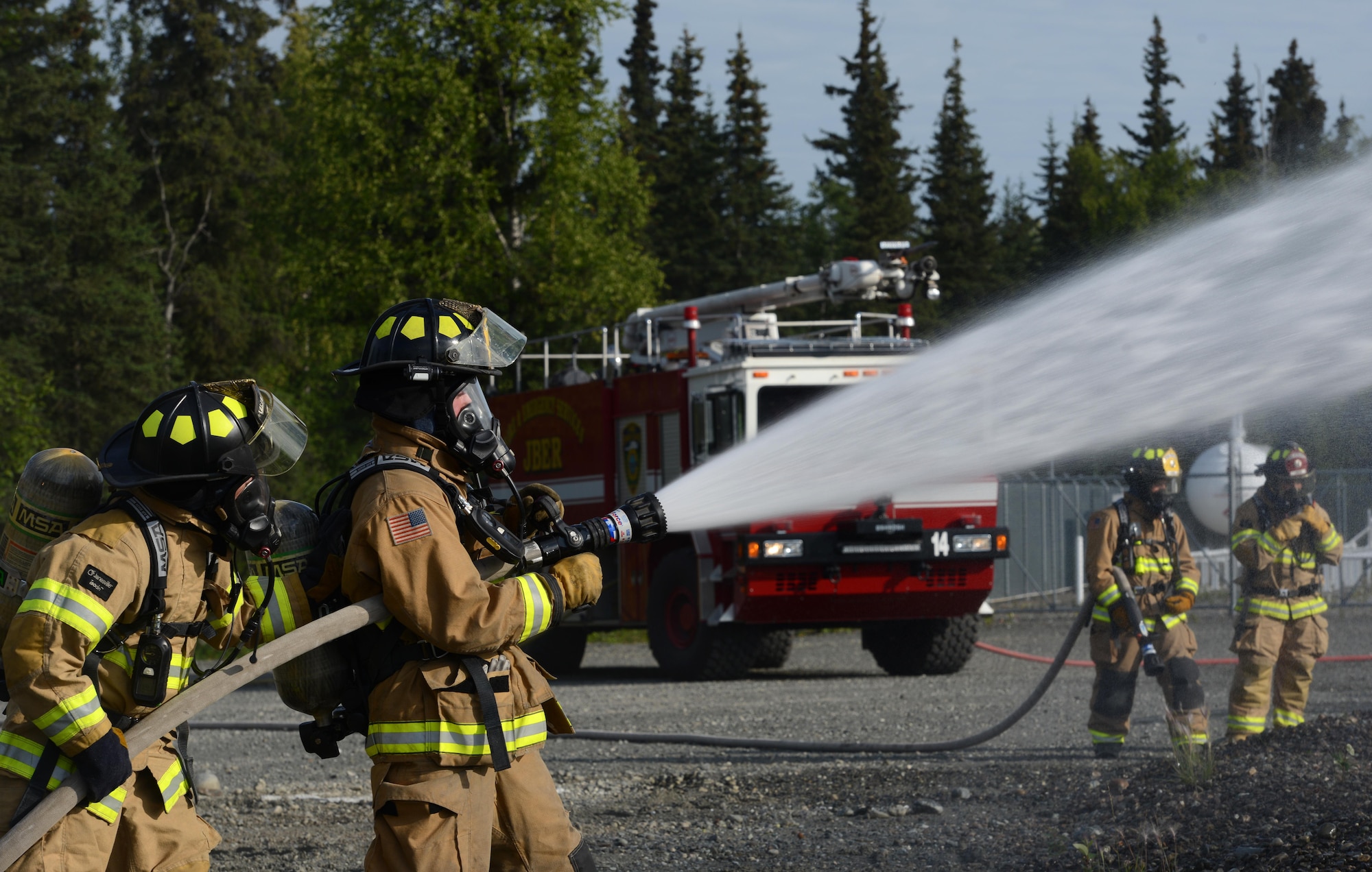 673d Civil Engineer Squadron firefighters extinguish a fire caused by a notional aircraft crash during Mission Assurance Exercise 16-7 at Joint Base Elmendorf-Richardson, Alaska, July 15, 2016. JBER simulated crash to test the base’s ability to operate, coordinate and recover in an efficient and timely manner. (U.S. Air Force photo by Airman 1st Class Christopher R. Morales)