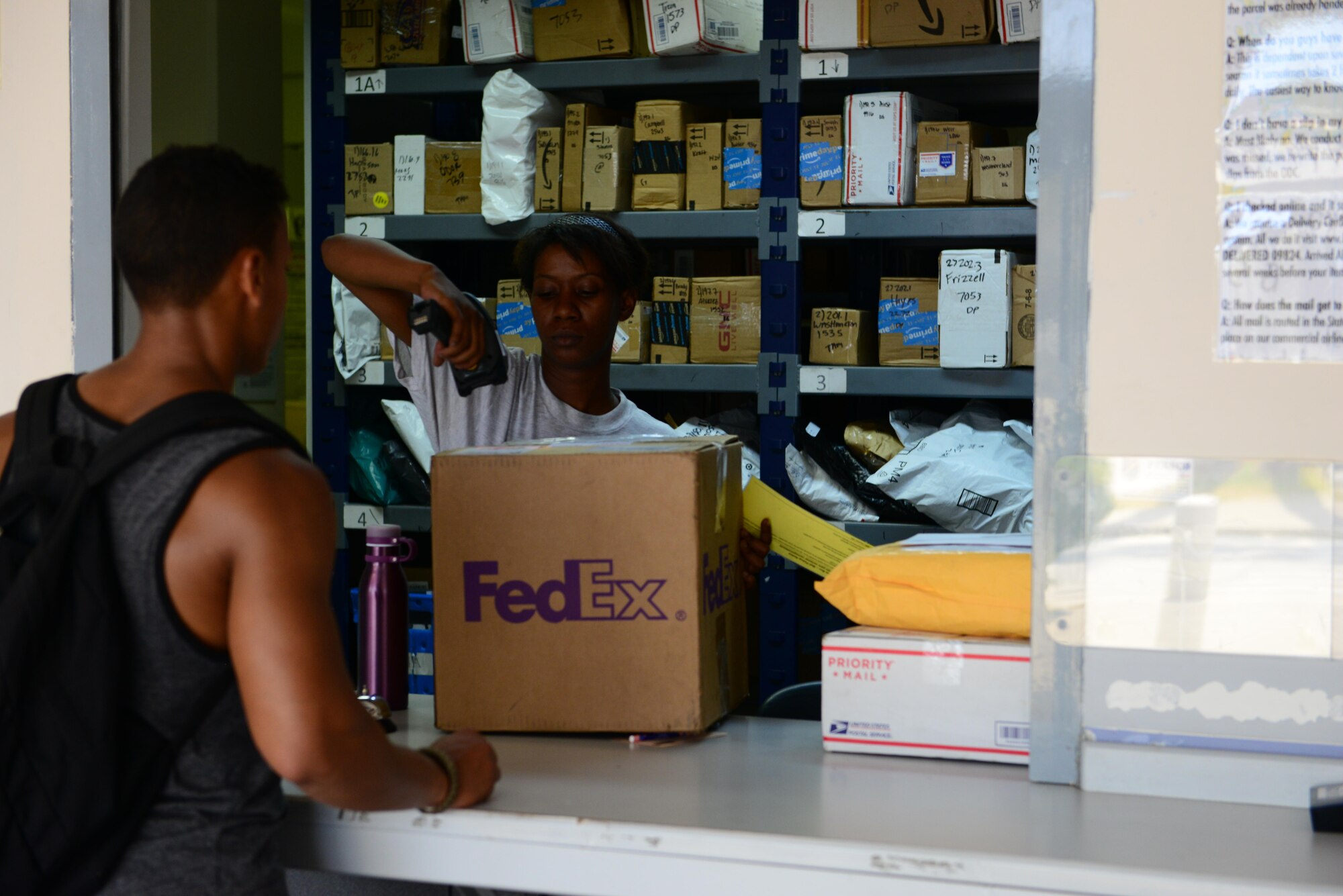 U.S. Air Force Senior Airman Adrianne Riley, 39th Communications Squadron postal clerk, delivers mail to a customer July 20, 2016, at Incirlik Air Base, Turkey. Due to an extended loss of commercial power, members of the Official Document Center operated under limited lighting conditions. (U.S. Air Force photo by Tech. Sgt. Caleb Pierce)