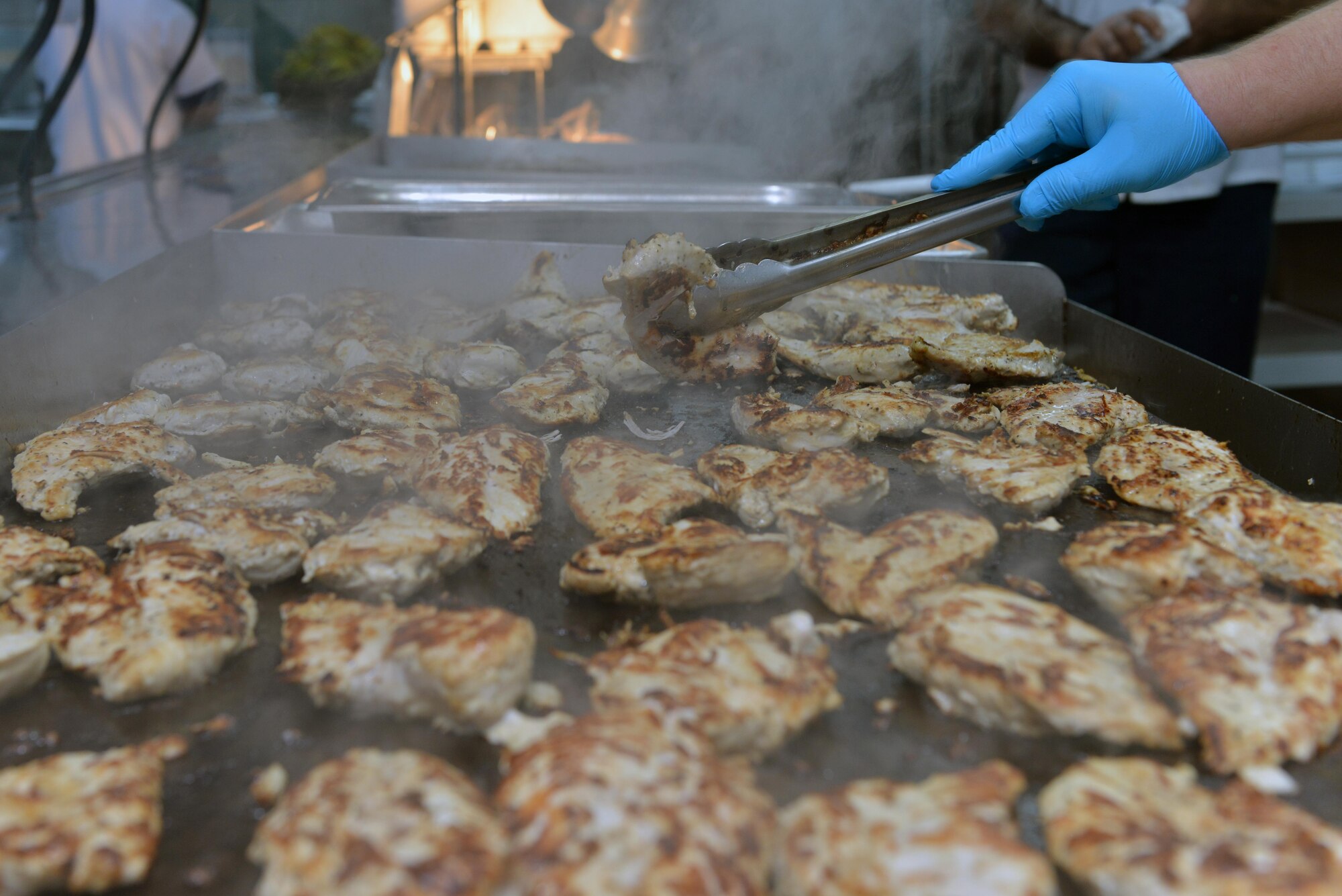 A Sultan’s Inn Dining Facility employee grills a plethora of chicken breasts in the Sultan’s Inn Dining Facility July 21, 2016, at Incirlik Air Base, Turkey. Grilled chicken breasts, along with pot roast, chicken a la king and steak and cheese sandwiches were some of the featured entrees. (U.S. Air Force photo by Senior Airman John Nieves Camacho)