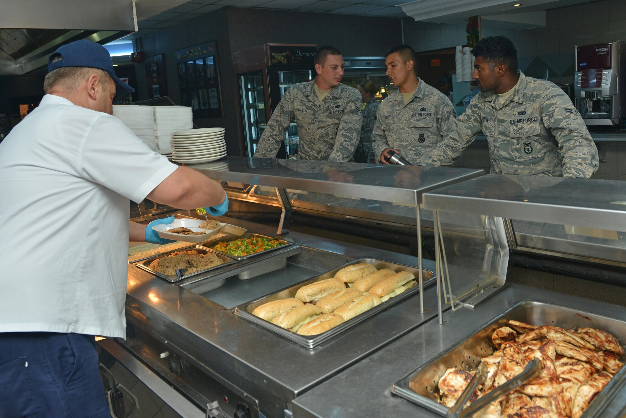 A Sultan’s Inn Dining Facility employee serves food for Airmen July 21, 2016, at Incirlik Air Base, Turkey. Services employees prepare, cook and serve food for dining facility patrons. (U.S. Air Force photo by Senior Airman John Nieves Camacho)