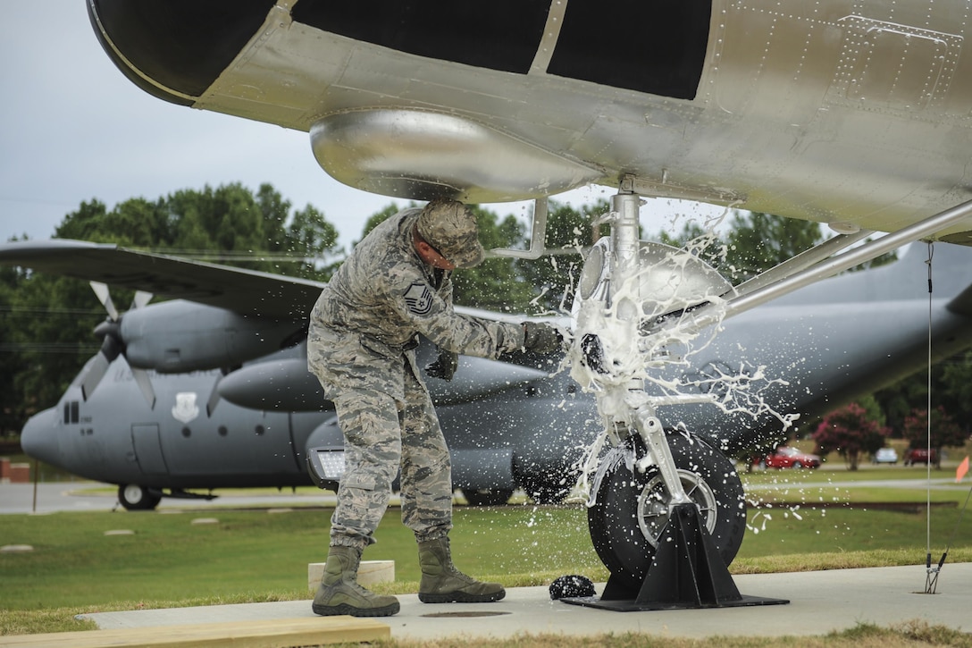 Master Sgt. Matthew Tabor, a 314th Maintenance Group quality assurance chief inspector, breaks a bottle to christen an H-21B helicopter in Heritage Park at Little Rock Air Force Base, Ark., July 14, 2016. Volunteers from the 314th MXG refurbished, transported and installed the H-21B static display. (U.S. Air Force photo/Senior Airman Harry Brexel)                           