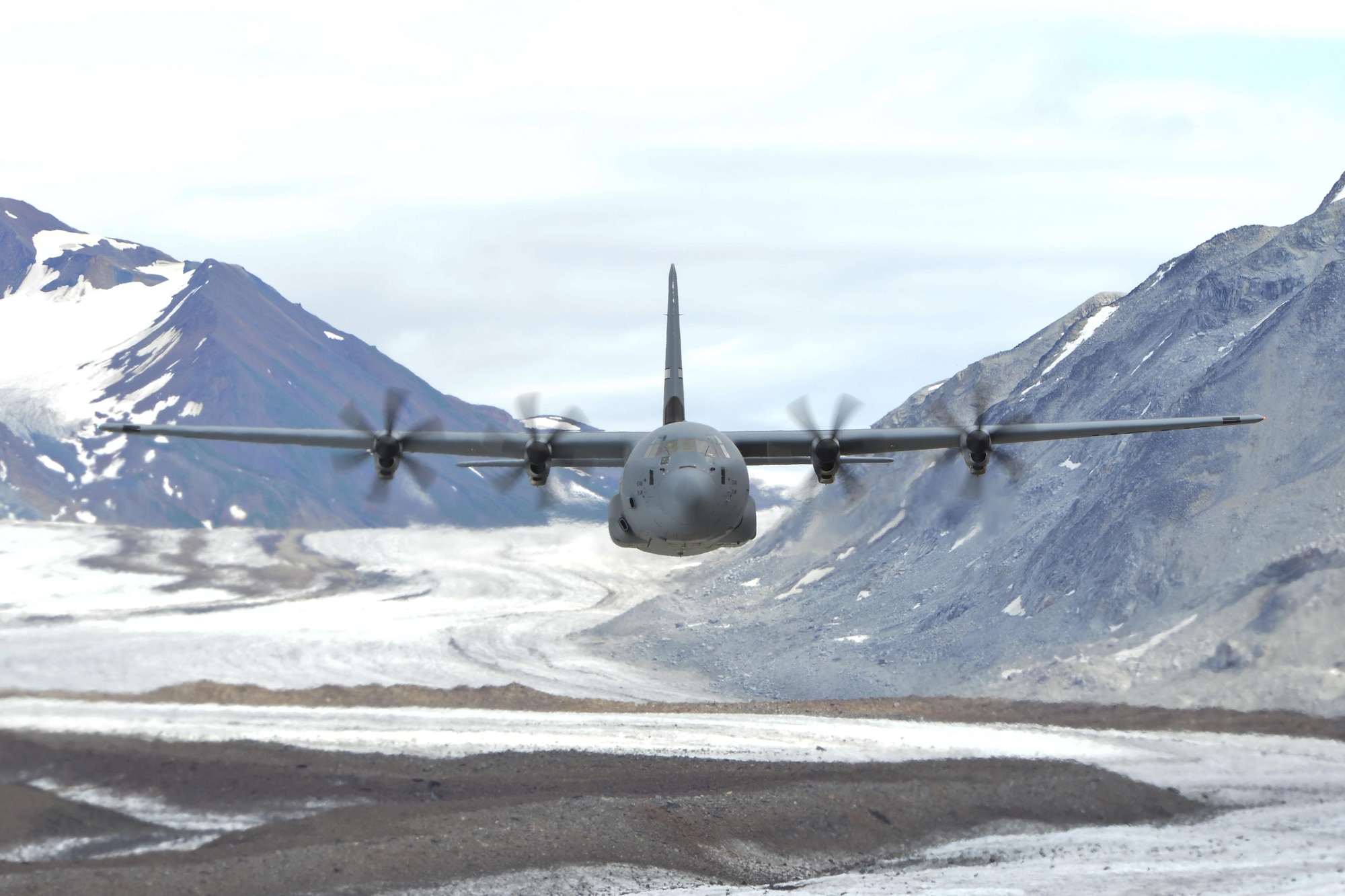 A Little Rock Air Force Base C-130J navigates the mountainous Alaskan terrain July 20, 2016. Team Little Rock delivers combat airlift to Alaska as part of pre-deployment training. The 41st AS is conducting training in Alaska to prepare for the terrain present in austere locations. Alaska provides an uncontended airspace which allows aircrews to train more effectively without having to adjust to commercial flight patterns. (U.S. Air Force photo by Senior Airman Kaylee Clark)