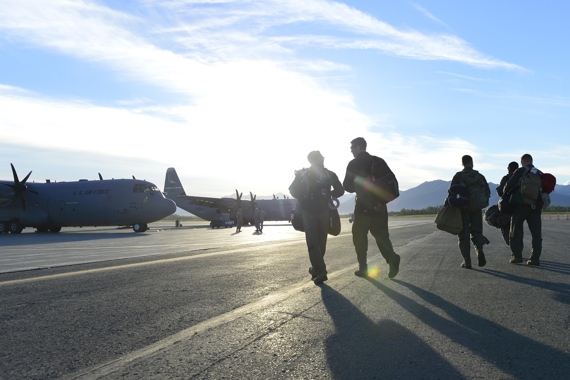 Aircrews from the 41st Airlift Squadron step to C-130Js prior to taking off on a predeployment training mission from Joint Base Elemendorf-Richardson, Alaska, July 19, 2016. The 41st AS is conducting training in Alaska to prepare for the terrain present in austere locations. Alaska provides an uncontended airspace which allows aircrews to train more effectively without having to adjust to commercial flight patterns. (U.S. Air Force photo by Senior Airman Kaylee Clark)