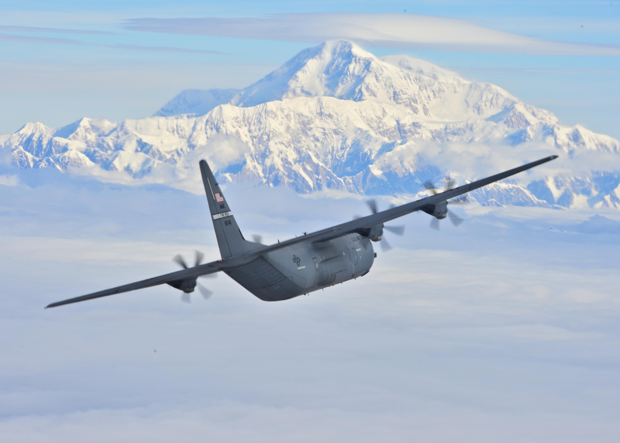 A C-130J from the 41st Airlift Squadron flies past Denali National Park's highest peak in North America July 19, 2016. Team Little Rock delivers combat airlift to Alaska as part  pre-deployment training. The 41st AS is conducting training in Alaska to prepare for the terrain present in austere locations. Alaska provides an uncontended airspace which allows aircrews to train more effectively without having to adjust to commercial flight patterns. (U.S. Air Force photo by Senior Airman Kaylee Clark)