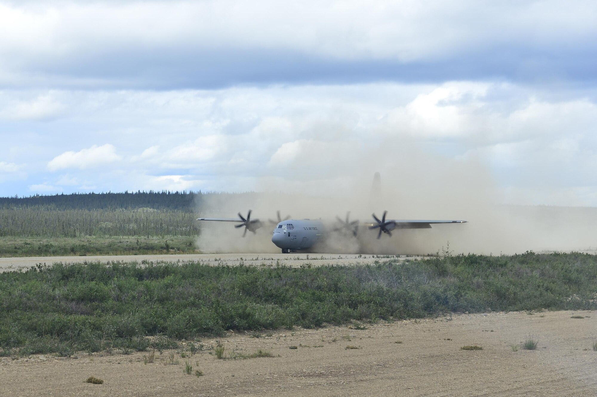 A C-130J from the 41st Airlift Squadron lands on a dirt landing strip in Alaska to simulate conditions found in various deployed locations July 20, 2016. Airmen from the 41st AS contributed to Exercise Arctic Anvil, a combined, joint and coalition training event. (U.S. Air Force photo by Senior Airman Kaylee Clark)