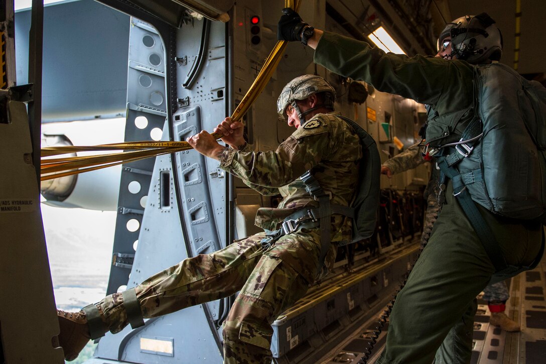 A soldier and airman pull in parachute deployment bags on a C-17 Globemaster III after a training jump to prepare for the Arctic Thunder Open House at Joint Base Elmendorf-Richardson, Alaska, July 20, 2016. The soldier is assigned to the 25th Infantry Division's 4th Brigade Combat Team and the airman is assigned to the 517th Airlift Squadron. Air Force photo by Senior Airman James Richardson