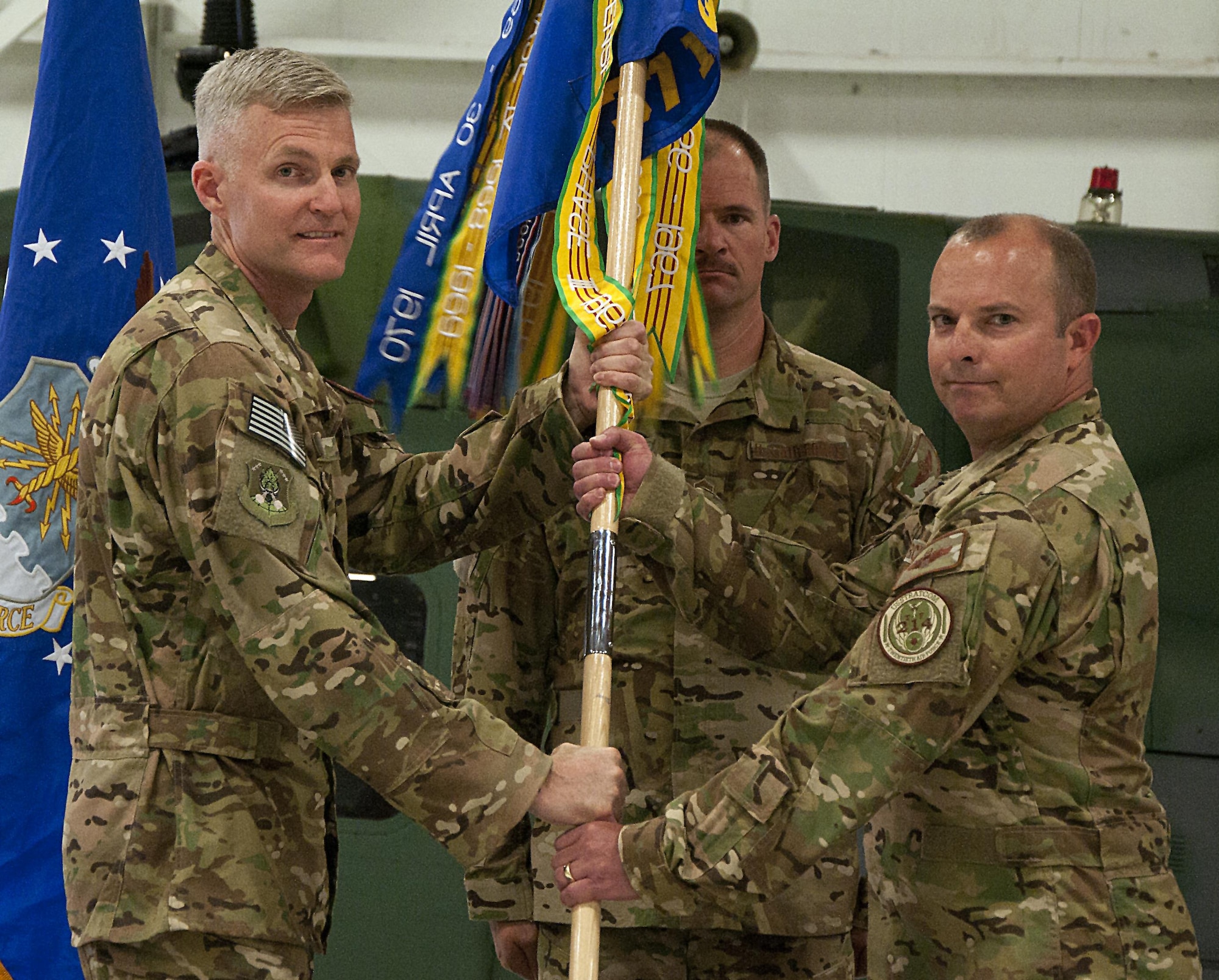 Col. David Smith, 582nd Helicopter Group commander, passes the guidon to Lt. Col. James Cline, 37th Helicopter Squadron commander, during the 37th HS change-of-command ceremony at F.E. Warren Air Force Base, Wyo., July 21, 2016. The ceremony signified the transition of command from Lt. Col. Todd Ivener to Cline. (U.S. Air Force photo by Senior Airman Brandon Valle)