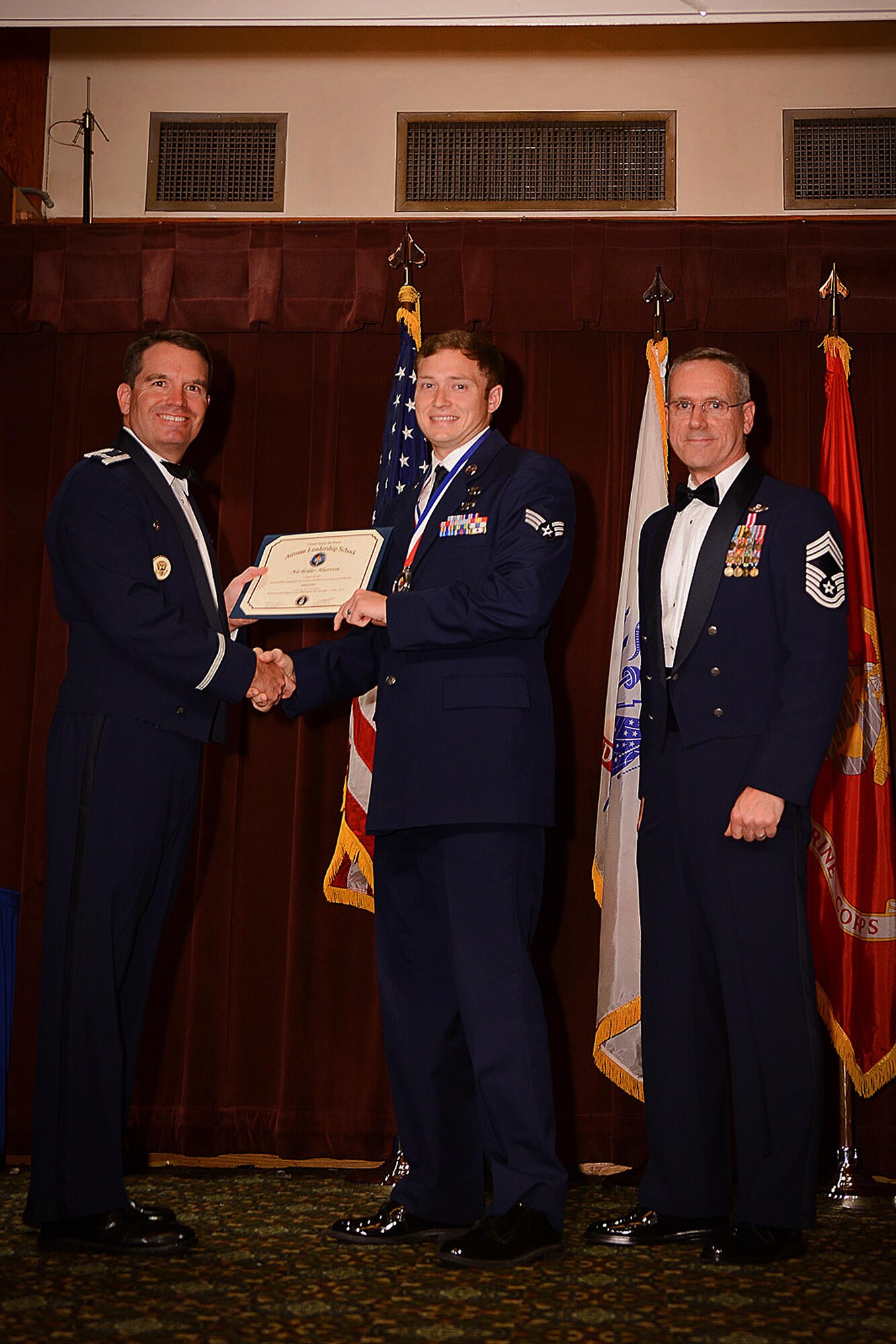 Staff Sgt. Nicholas Hurren (Center), 5th Air Support Operations Squadron tactical air control party, receives a certificate of graduation from the Julius A. Kolb Airman Leadership School during a graduation ceremony May 10, 2016 at Joint Base Lewis-McChord, Wash. Hurren is also a graduate from U.S. Marine Corps Corporals Leadership Course held at Naval Base Kitsap-Bangor, Wash. (Courtesy photo) 