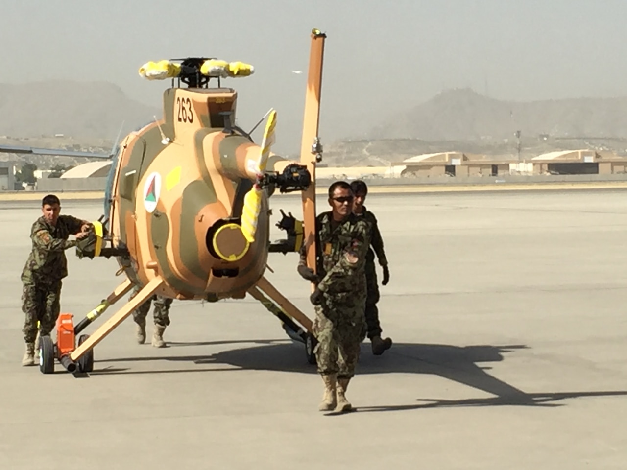 Members of the Afghan air force wheel out a new MD-530 Cayuse Warrior helicopter at the 438th Air Expeditionary Wing/Train, Advise, Assist Command-Air in Kabul, Afghanistan, July 16, 2016. 