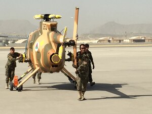 Members of the Afghan air force wheel out a new MD-530 Cayuse Warrior helicopter