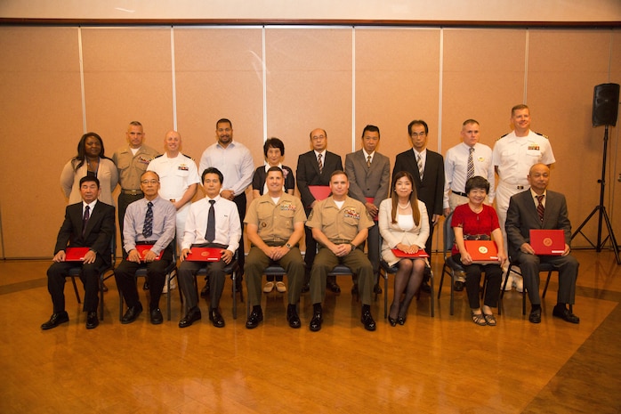 Retirees and members of Marine Corps Air Station Iwakuni leadership pose for a photo during a retirement ceremony at the Landing Zone in Club Iwakuni on MCAS Iwakuni, Japan, July 15, 2016.  The ceremony acknowledged the appreciation for the retirees’ hard work and dedication toward the installation’s success over the years.  (U.S. Marine Corps photo by Lance Cpl. Jacob Farbo)