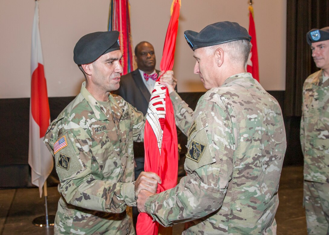 Maj. Gen. Richard L. Stevens (right), deputy commanding general of the U.S. Army Corps of Engineers passes the Corps flag to Col. Rafael F. Pazos, incoming commander of the Corps’ Japan District during a Change of Command Ceremony, July 8, 2016. The passing of the colors symbolizes the formal relinquishing of command from outgoing commander Col. John S. Hurley to incoming commander Pazos. (USACE Photos)