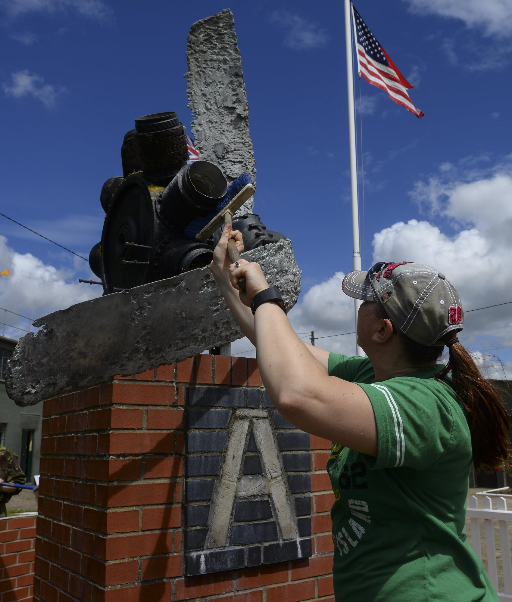 U.S. Air Force Tech. Sgt. Tracy Thorpe, 373rd Training Squadron KC-135 avionics instructor, cleans a monument on display July 17, 2016, at the RAF Rougham Tower Museum in Bury St. Edmunds, England.  Volunteers from the Air Force Sergeants' Association visited the museum to perform minor landscaping. (U.S. Air Force photo by Staff Sgt. Micaiah Anthony)