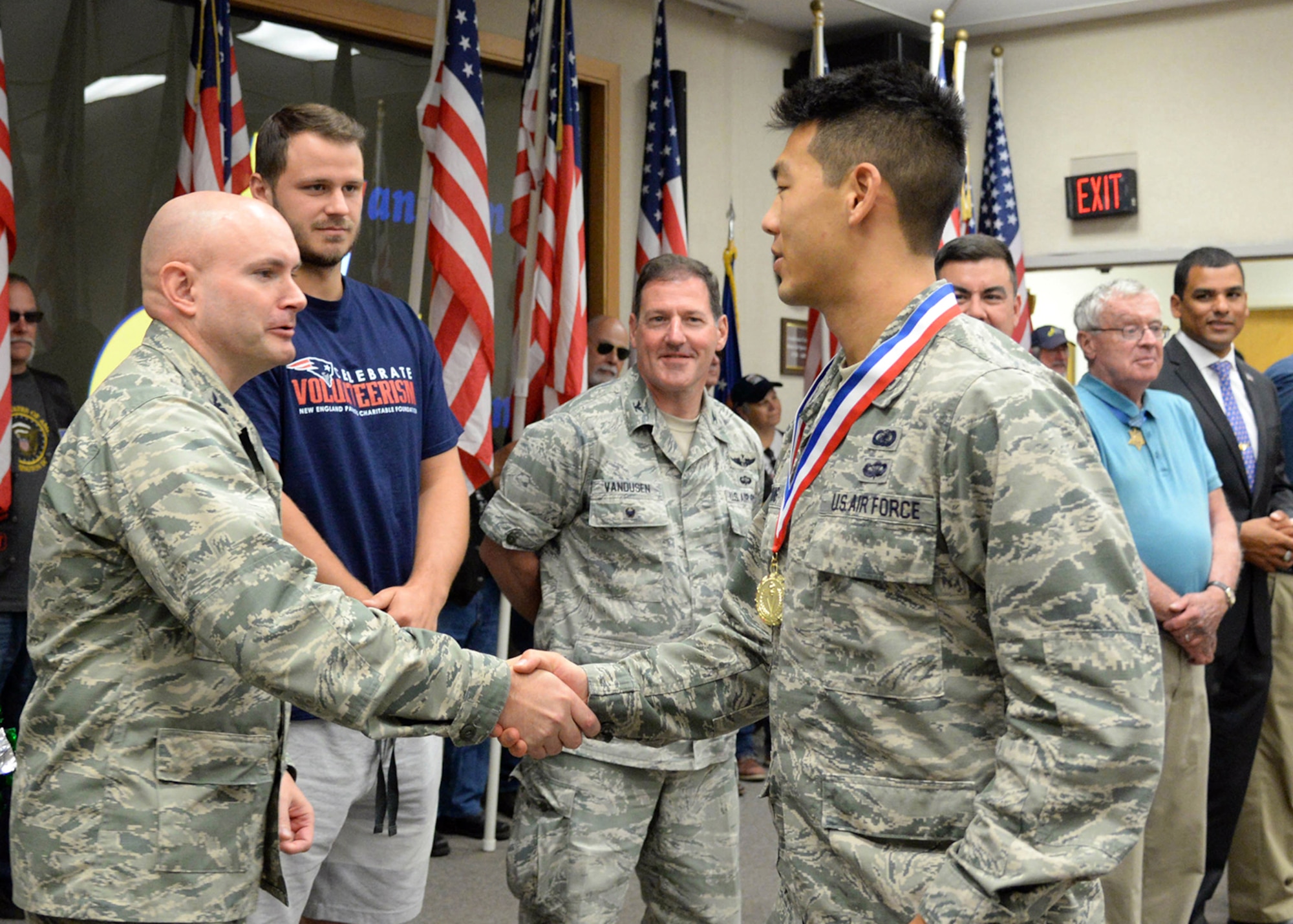 First Lt. Brian Hwang, a contracting manager for the Battle Management Air Operations Center program, is welcomed home by Col. David R. Dunklee, installation commander, during the Hanscom Heroes Homecoming medallion ceremony at the base conference center July 21. During the event, base personnel formally welcomed home military and civilian Airmen, along with their families, who have returned home from deployment in the past year. (U.S. Air Force photo by Linda LaBonte Britt)