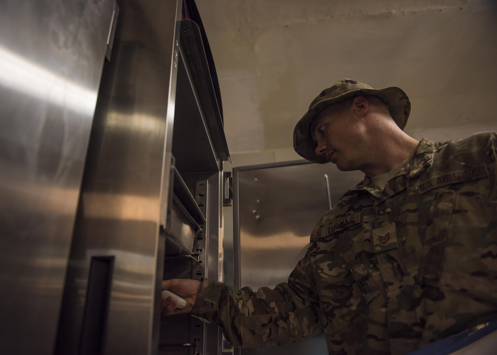 Tech Sgt. Rusty Thomas, 455th Expeditionary Medical Group public health technician, checks food temperature with an infrared thermometer, Bagram Airfield, Afghanistan, July 21, 2016. The infrared thermometer scans the outside temperature of the food to ensure it is served according to the health code standard. (U.S. Air Force photo by Senior Airman Justyn M. Freeman)
