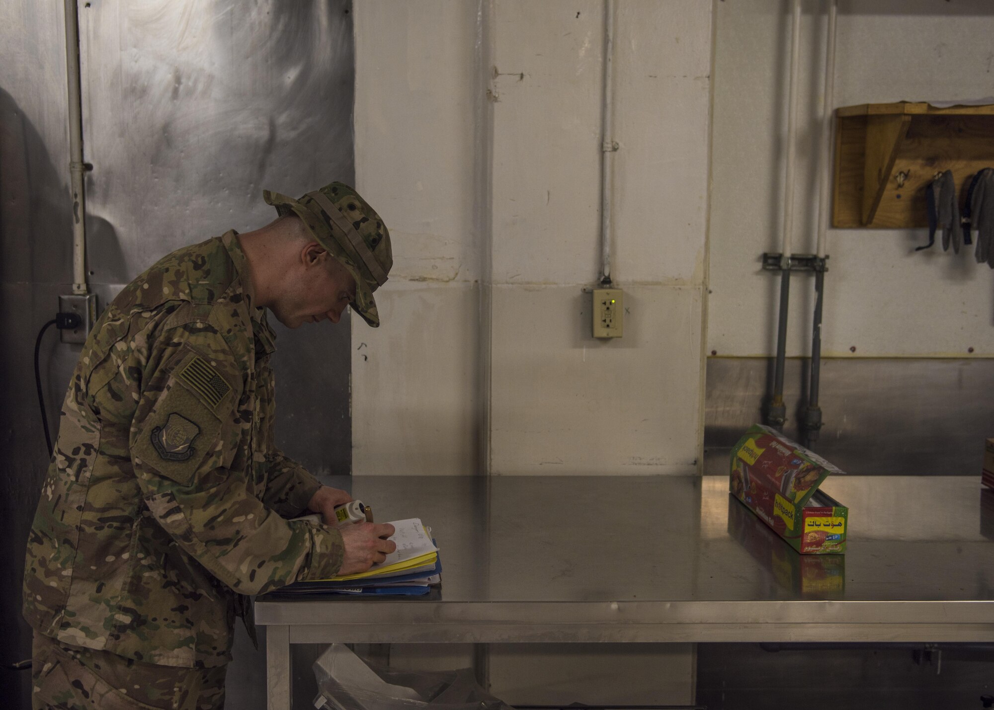 Tech Sgt. Rusty Thomas, 455th Expeditionary Medical Group public health technician, takes notes, Bagram Airfield, Afghanistan, July 21, 2016. Thomas randomly inspects the dining facilities on base once a month to confirm food preparation and handling are conducted to health code standards. (U.S. Air Force photo by Senior Airman Justyn M. Freeman)