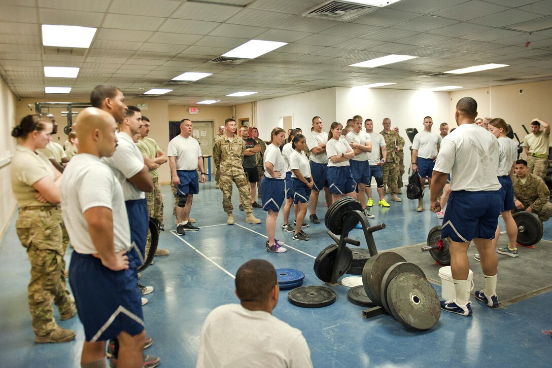 Airmen and Air Force civilians receive a briefing before participating in the deadlift portion of a powerlifting competition at Bagram Airfield, Afghanistan, July 15, 2016. The airmen are assigned to the 455th Expeditionary Aircraft Maintenance Squadron. Air Force photo by Capt. Korey Fratini