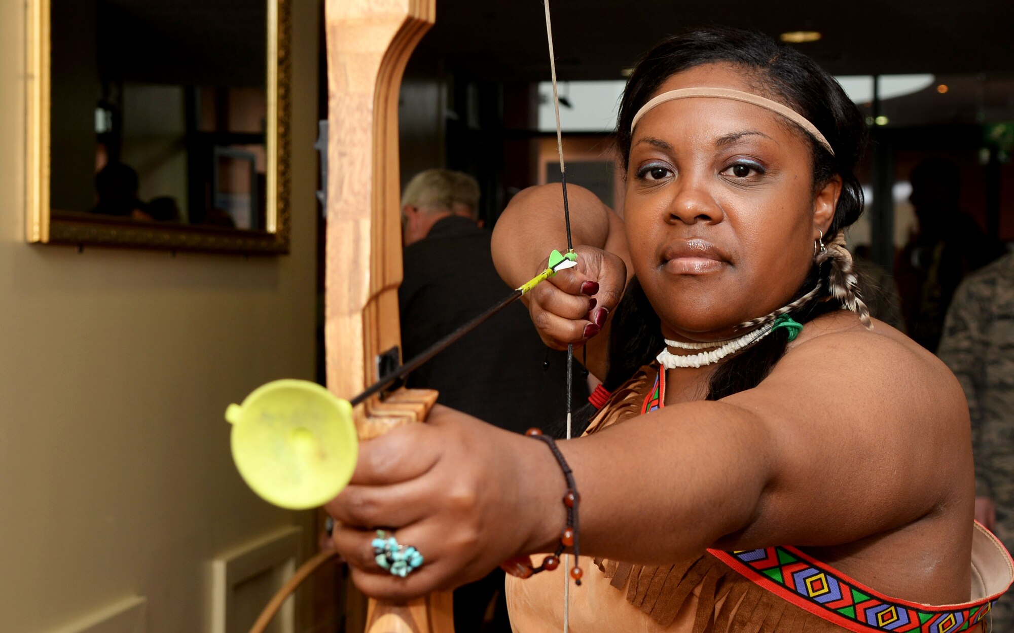 U.S. Air Force Master Sgt. Vivian S. Lewis, 100th Force Support Squadron career assistant advisor, shoots a bow-and-arrow at Team Mildenhall’s Diversity Day celebration July 15, 2016, on RAF Mildenhall, England. Lewis was dressed in Native American attire to highlight their culture and heritage. (U.S. Air Force photo by Airman 1st Class Tenley Long)
