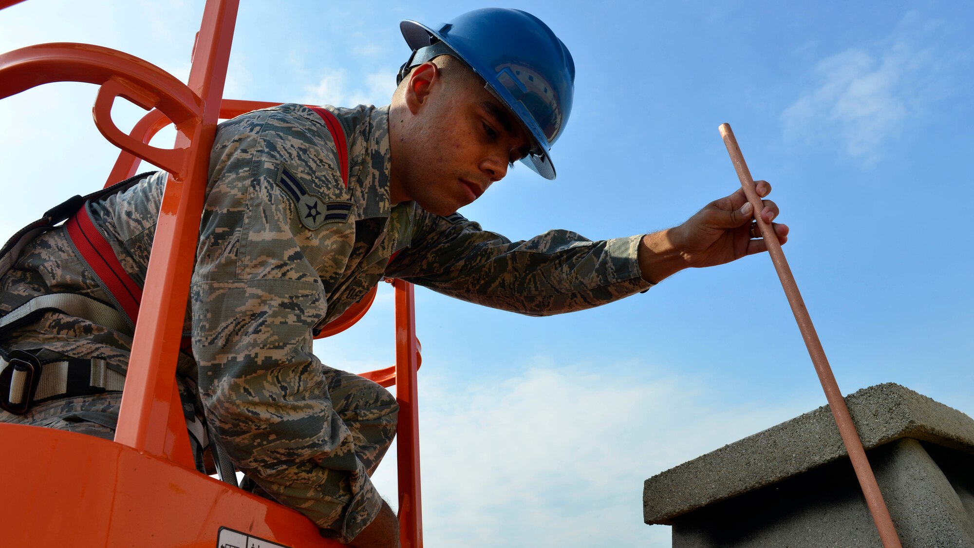Airman 1st Class John Chavez, 31st Civil Engineer Squadron electrical systems journeyman, installs a lightning protection rod, July 20, 2016, at Aviano Air Base, Italy. Lightning rods are intended to safely direct the lightning’s electrical current to a grounded copper wire. (U.S. Air Force photo by Airman 1st Class Cary Smith/Released)