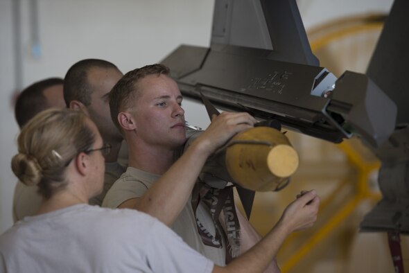 Airmen from the 33th Aircraft Maintenance Squadron load an AIM-9X missile on to an F-35A’s external weapons pylon July 20, 2016, at Eglin Air Force Base, Fla. This milestone was the first time an F-35A at Eglin AFB was loaded with internal and external weapons and will help develop weapons loading procedures for the F-35 program. (U.S. Air Force photo by Senior Airman Stormy Archer)