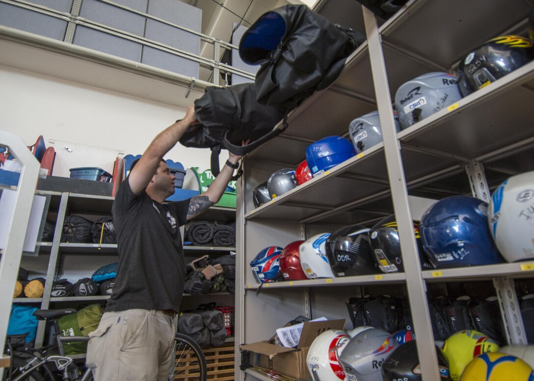 Todd Spencer, 31st Force Support Squadron Outdoor Recreation equipment maintenance professional, grabs an inflatable kayak from a shelve July 20, 2016, at Aviano Air Base, Italy. Outdoor Recreation offers programs like scuba diving and lifeguarding certification, as well as swimming, skiing and snowboarding lessons. (U.S. Air Force photo by Airman 1st Class Cory W. Bush/Released)