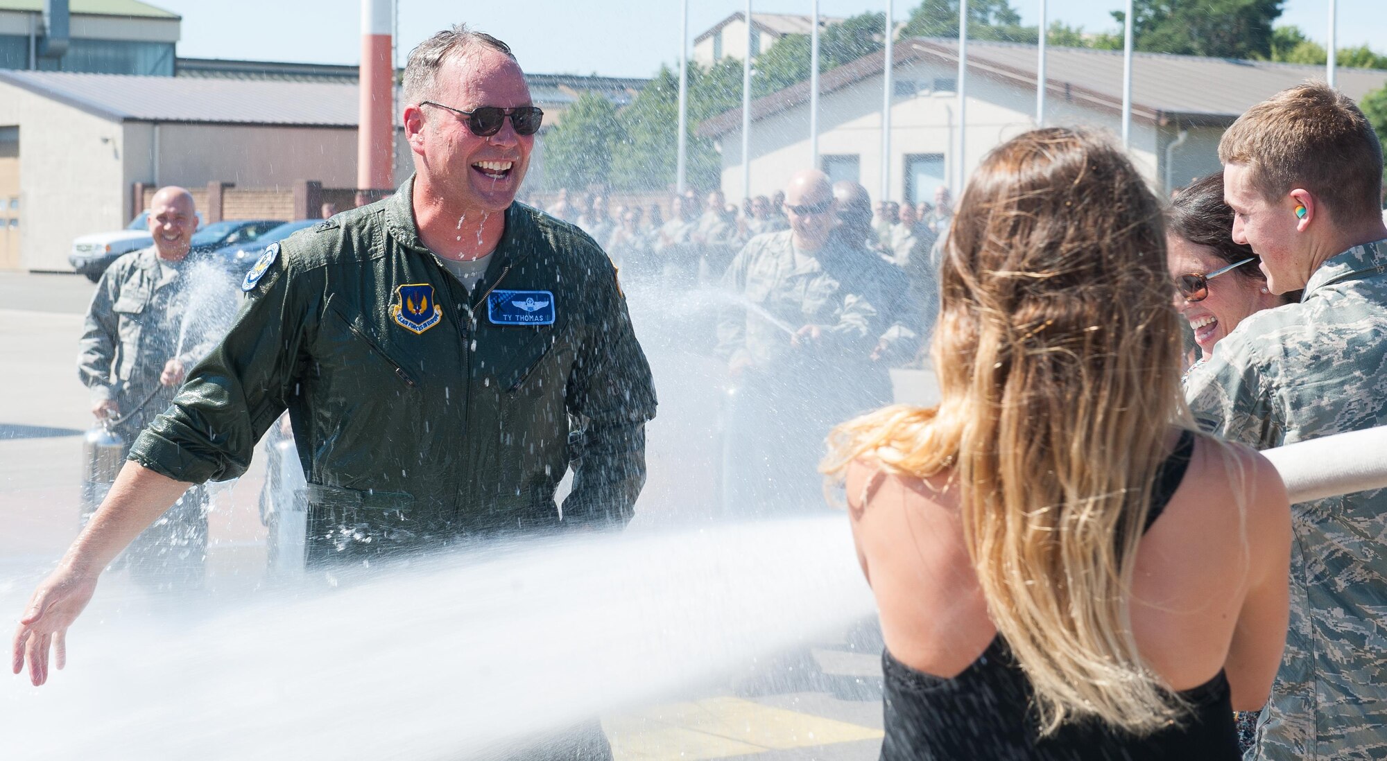 Brig. Gen. Jon T. Thomas, 86th Airlift Wing commander, approaches his family as he gets hosed down with water during his “fini flight” July 20, 2016, at Ramstein Air Base, Germany. Fini flights have been a tradition for pilots that are changing bases since World War II. The pilots fly their assigned aircraft one last time, and are greeted by Airmen, family and friends after landing. (U.S. Air force photo/Airman 1st Class Lane T. Plummer)