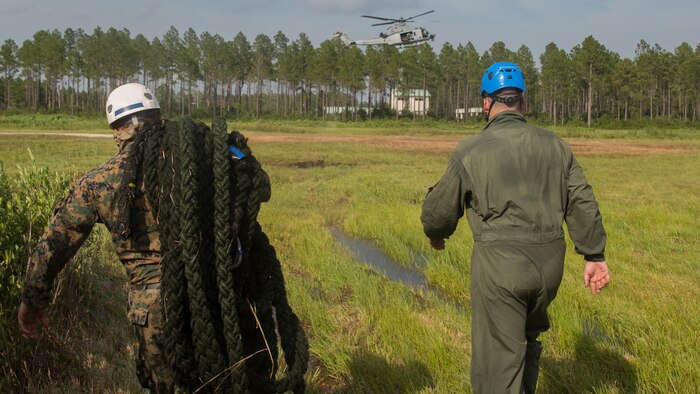 Marine instructors with Expeditionary Operations Training Group approach a UH-Y1 Huey in preparation for fast rope drills during elevator operations at Landing Zone Kingfisher, Marine Corps Base Camp Lejeune, N.C., July 13, 2016. The fast rope masters course, a week-long training event, is the first of its kind and focuses solely on techniques, procedures, and safety that comes along with fast roping with a combat load.