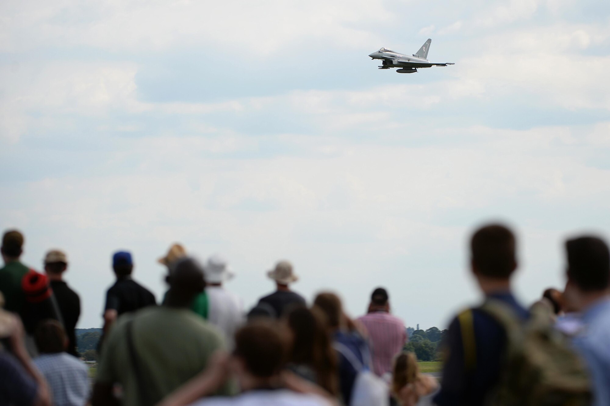 Spectators view a Royal Air Force Typhoon FGR4 perform during a demonstration at the Families and Friends Day celebration at RAF Marham, England, July 21. Airmen from RAFs Lakenheath and Mildenhall were invited to celebrate RAF Marham's 100th anniversary and to continue building build a closer partnership between bases. (U.S. Air Force photo/Staff Sgt. Emerson Nuñez)