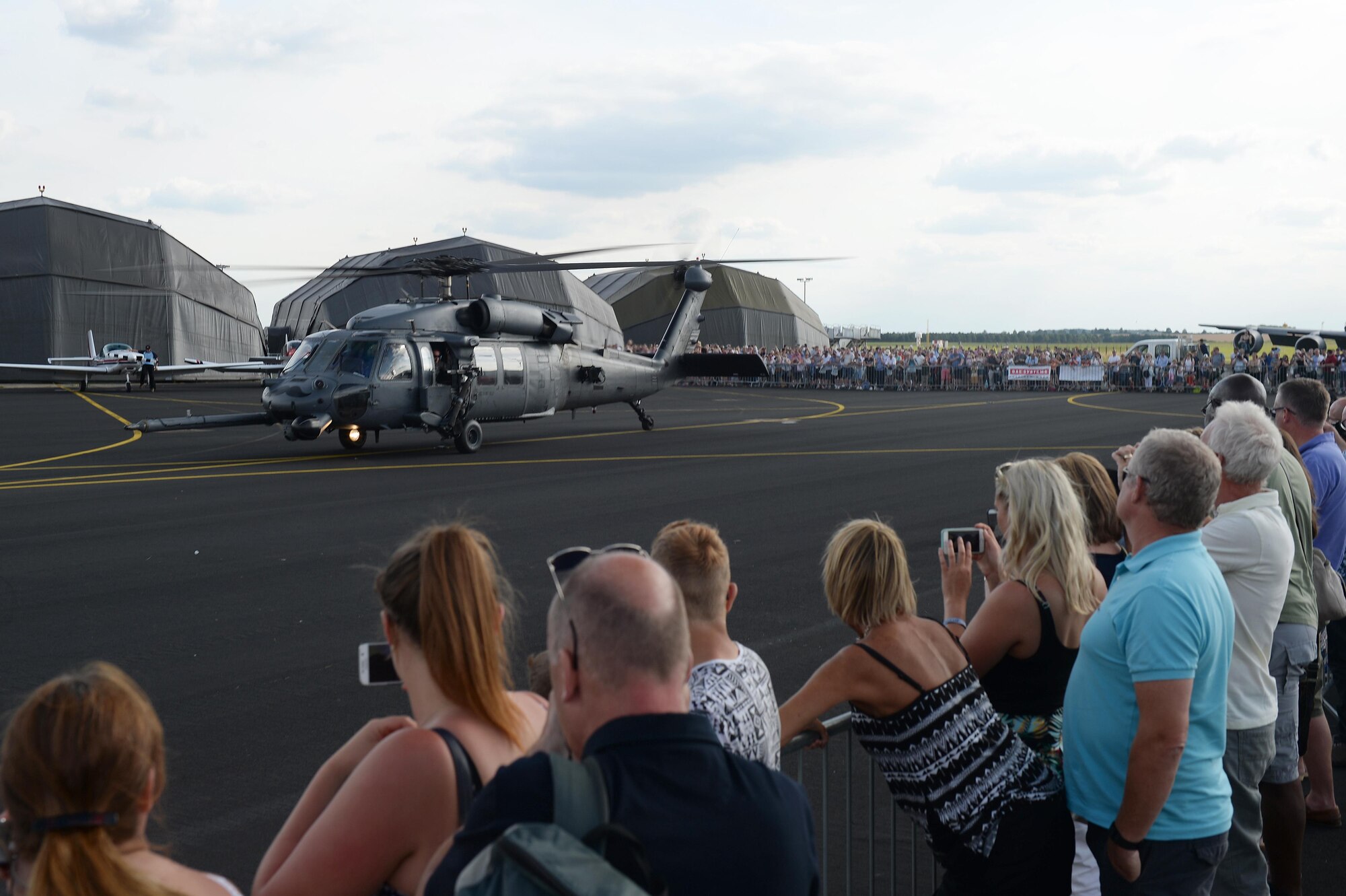 Spectators watch as a U.S. Air Force HH-60G Pave Hawk assigned to the 56th Rescue Squadron from Royal Air Force Lakenheath takes off from the flightline during the Families and Friends Day celebration at RAF Marham, England, July 21. RAF Marham hosted the event with a three-and-a-half hour flight display, static displays, food booths, shopping, rides and evening concert to ensure guests of all ages enjoyed the day. (U.S. Air Force photo/Staff Sgt. Emerson Nuñez)