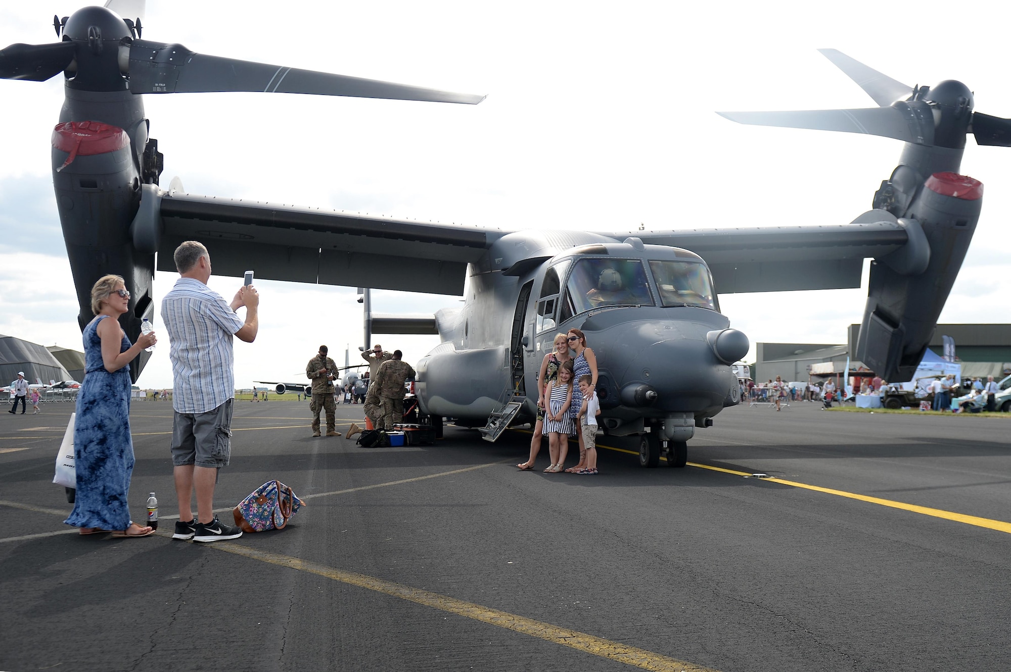 Visitors take a photo in front of a U.S. Air Force CV-22 Osprey assigned to the 7th Special Operations Squadron from Royal Air Force Mildenhall during the Families and Friends Day celebration at RAF Marham, England, July 21. The event celebrated RAF Marham's 100th anniversary and welcomed Airmen from RAFs Lakenheath and Mildenhall, as well as their families and local dignitaries to enjoy the festivities. (U.S. Air Force photo/Staff Sgt. Emerson Nuñez)