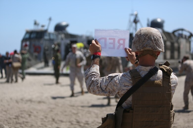 U.S. Marines with Landing Support Company, 1st Transportation Support Battalion, 1st Marine Logistics Group, guide distinguished visitors off of a landing craft, air cushion during PACOM Amphibious Leaders Symposium – 16 aboard Camp Pendleton, Calif., July 13, 2016. Several 1st MLG units and Beachmaster Unit 1, Naval Beach Group 1 facilitated the offload of equipment and personnel during the symposium’s beach landing operations demonstration. (U.S. Marine Corps photo by Sgt. Carson Gramley/released)