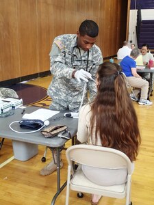 Spc. Xavier Ruiz, a licensed practical nurse from Company A, 48th Combat Support Hospital, Fort Story, Va., takes vital signs from a community member during the Greater Chenango Cares Innovative Readiness Training event, July 19, 2016.  Greater Chenango Cares is one of the Innovative Readiness Training events which provides real-world training in a joint civil-military environment while delivering world class medical care to the people of Chenango County, N.Y., from July 15-24.