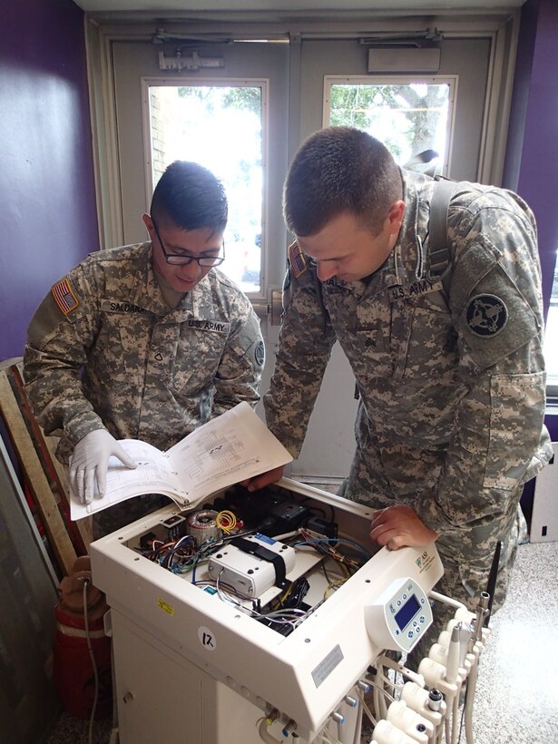 Sgt. Christopher Ramos, a biomedical technician from Company A, 48th Combat Support Hospital, Fort Story, Va., and Pfc. Albertico Saldana, a biomedical technician from the 341st Medical Logistics, Newtown Square, Pa. perform maintenance on a piece of dental equipment during Greater Chenango Cares, July 20, 2016.  Greater Chenango Cares is one of the Innovative Readiness Training events which provides real-world training in a joint civil-military environment while delivering world class, no-cost medical, dental, optometry and veterinary care to the people of Chenango County, N.Y., from July 15-24.