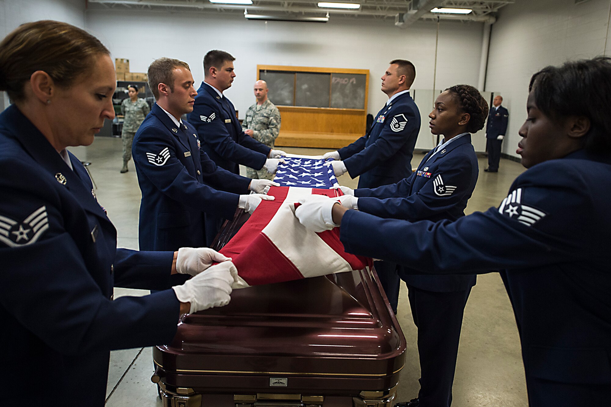 New members of the Grissom Honor Guard demonstrate proper flag folding during their graduation from the Honor Guard training course July 15, 2016 at Grissom Air Reserve Base, Ind. The training course is one week long and involves learning new facing movements, proper flag folding, casket carrying and use of the M14 rifle for ceremonies. (U.S. Air Force photo/Senior Airman Dakota Bergl)