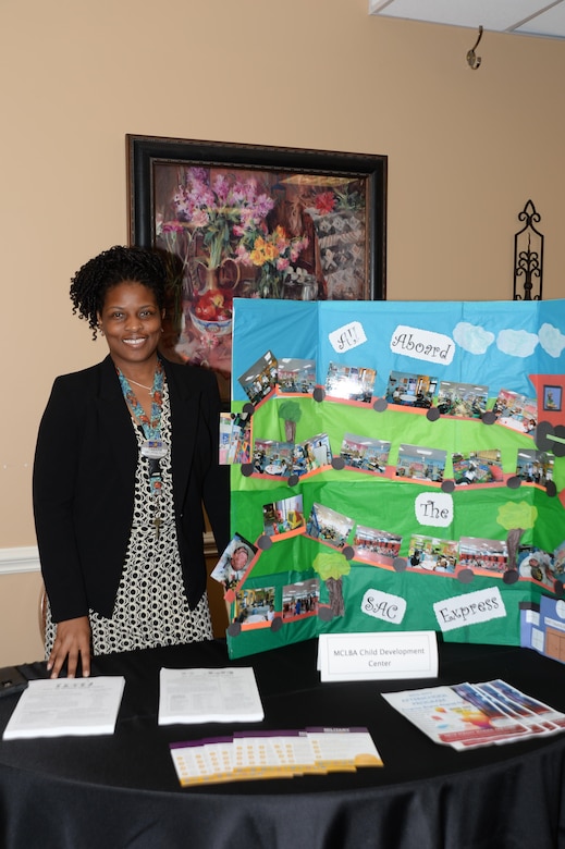 Tamara K. Wilson, operations assistant, Child Development Center, Marine Corps Logistics Base Albany, attends to an information table during the third annual educational summit held at the Town and Country Grand Ballroom aboard Marine Corps Logistics Base Albany, July 21. 
