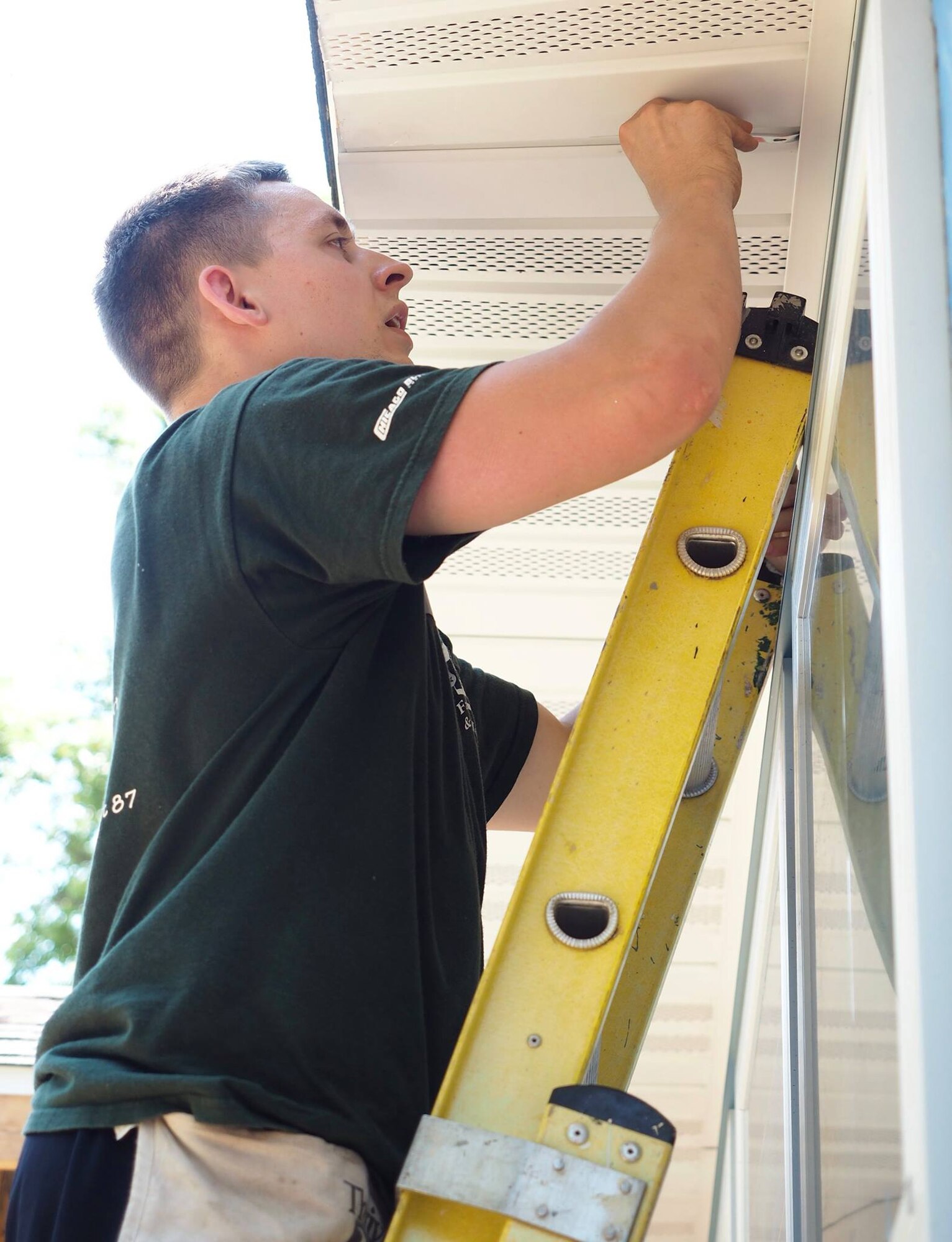 Staff Sgt. Larry Baca, 934th Financial Management, installs soffit panels during a Habitat for Humanity project July 20.