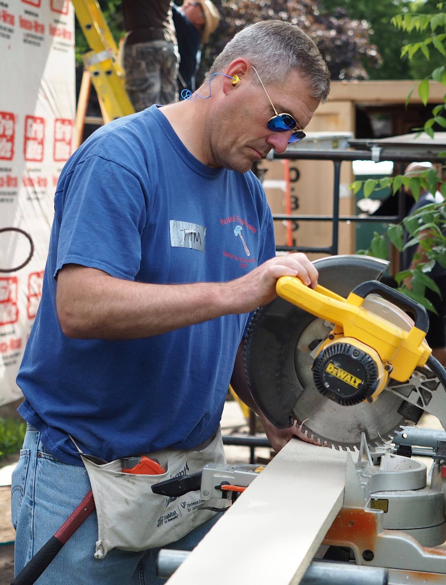 Col. Tim Wollmuth, 934th Airlift Wing vice commander, saws siding trim for the Habitat for Humanity home building project July 20.