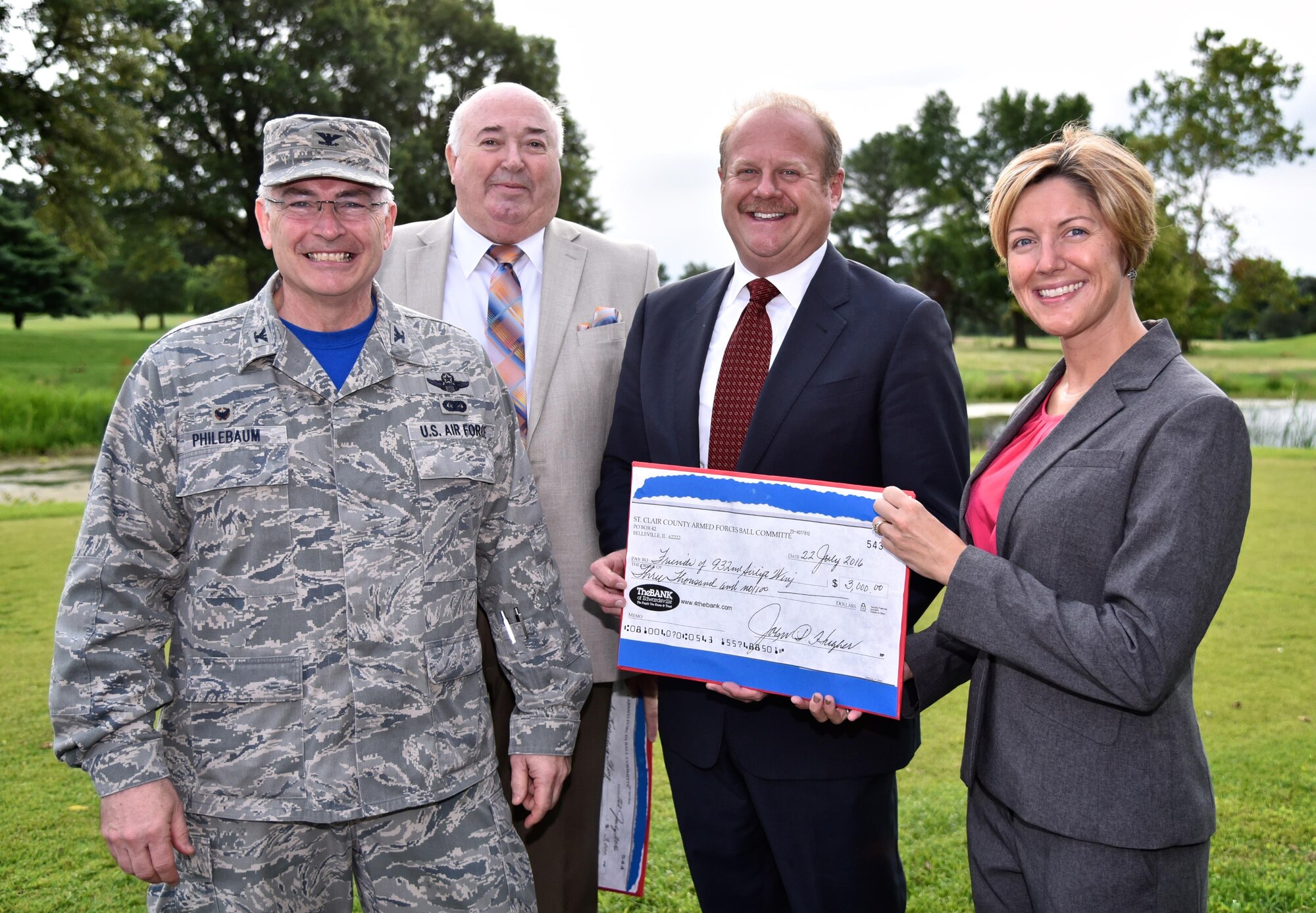 Mark Kern, blue suit, St. Clair County Chairman, and John Hughes, beige suit, director of military affairs, St. Clair County present Liz Wszalek, board member for Friends of 932nd Airlift Wing and Col. Jonathan Philebaum, 932nd AW commander a check from the St. Clair County Armed Forces Ball Committee July 22, 2016, Scott Air Force Base, Illinois. The donation will be used to support families within the 932nd AW.  (U.S. Air Force photo/Christopher Parr)