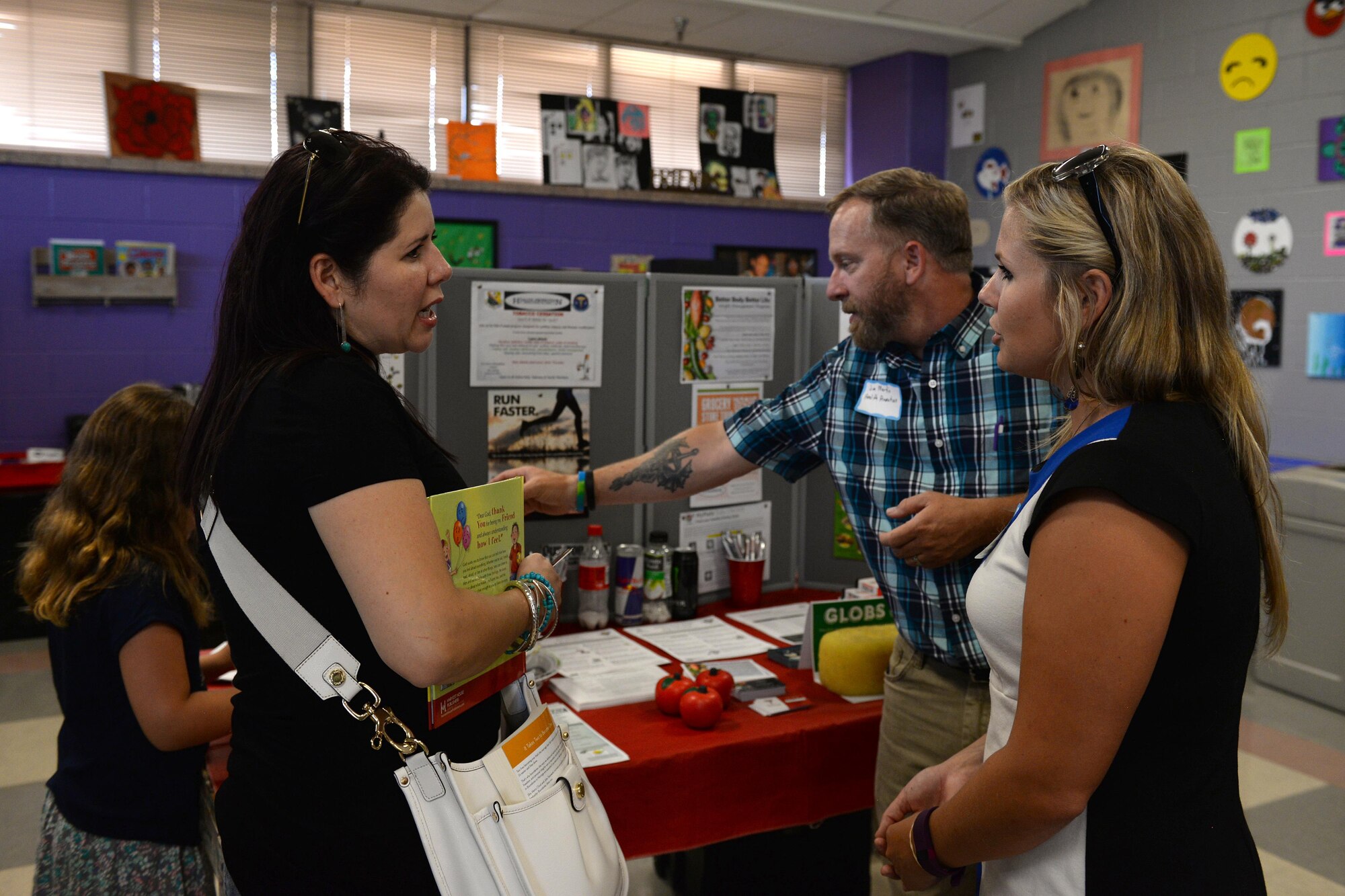 Carolys Thompson, spouse of Master Sgt. Brandon Thompson, 82nd chapel operations superintendent, talks with Sara Peacock, 82nd Aerospace Medicine Squadron registered dietitian, about services health promotions offers at Sheppard Air Force Base, Texas, July 20, 2016. The summer family picnic had several booths from various helping agencies to help introduce and welcome new families to the base. (U.S. Air Force photo by Senior Airman Kyle E. Gese/Released)