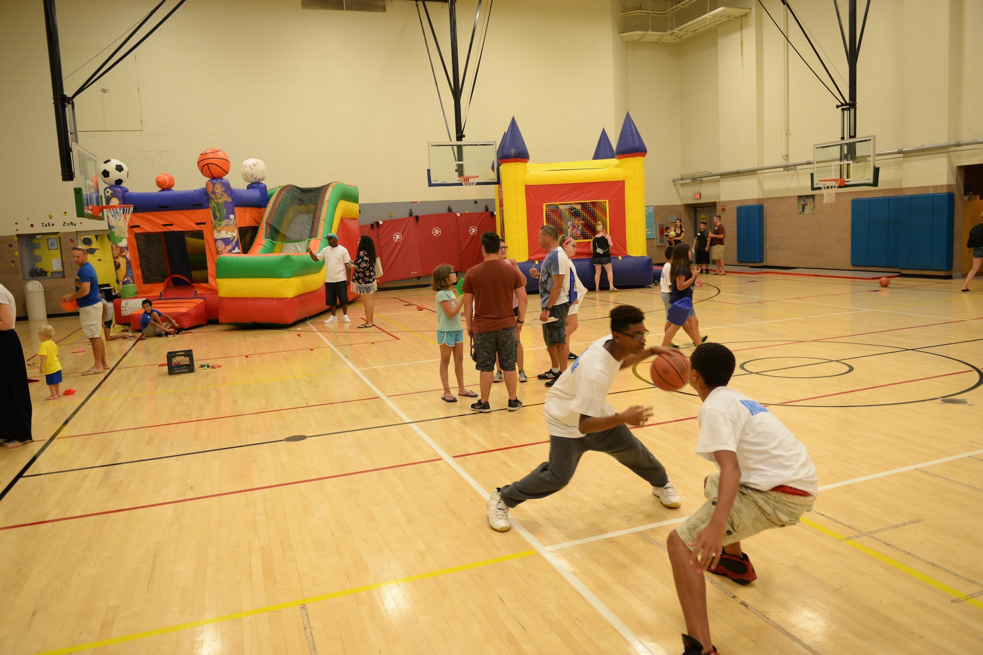 Families play in the Sheppard Air Force Base youth center gym during the summer family picnic, July 20, 2016. The summer family picnic had several booths from various helping agencies to help introduce and welcome new families to the base. (U.S. Air Force photo by Senior Airman Kyle E. Gese/Released)
