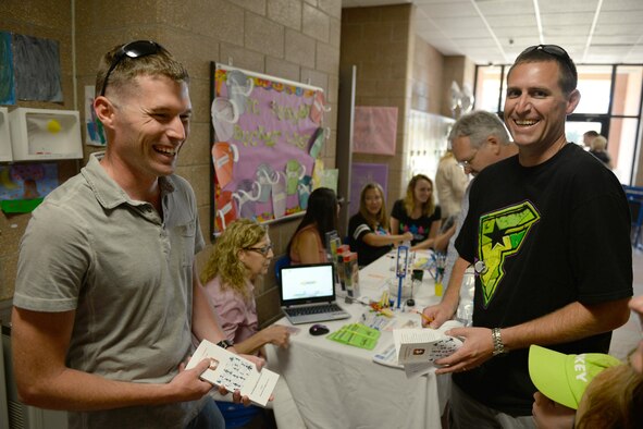 Staff Sgt. Robert Kusina, 365th Training Squadron avionics instructor, welcomes Tech. Sgt. Steven Dymond, 82nd Comptroller Squadron NCO in charge of customer support, to Sheppard Air Force Base, Texas, during the summer family picnic, July 20, 2016. The summer family picnic had several booths from various helping agencies to welcome and introduce new families to the base. (U.S. Air Force photo by Senior Airman Kyle E. Gese/Released)