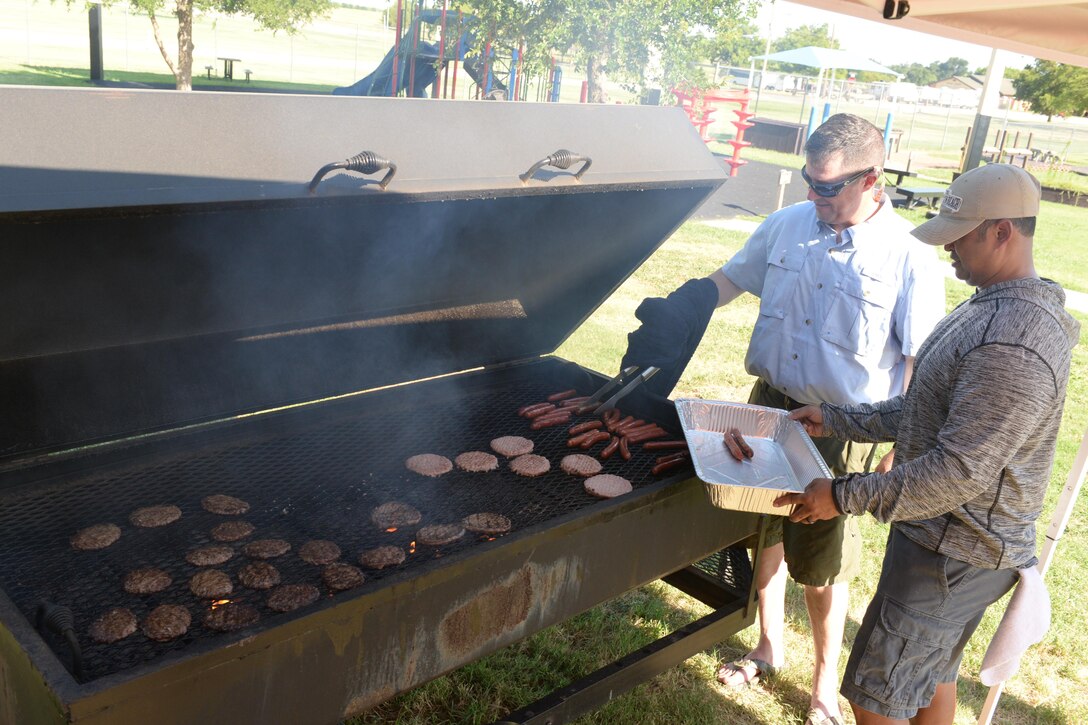 Chief Master Sgt. Joseph Pritchard, 82nd Training Wing command chief, and Chief Master Sgt. Eric Dudash, 372nd Training Squadron superintendent, grill food for the summer picnic at Sheppard Air Force Base, Texas, July 20, 2016. The picnic hosted several base helping agencies to welcome new families to the base and community. (U.S. Air Force photo by Senior Airman Kyle E. Gese/Released)