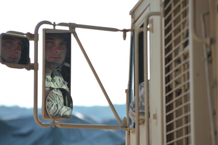 Army Reserve Spc. Eric V. Milliner, 424th Transportation Company, Gallax, Virginia, watches the flagger direct him as he backs up to the load during Warrior Exercise (WAREX) 86-16-03 at Fort McCoy, Wis., July 20, 2016. WAREX is designed to keep Soldiers all across the United States ready to deploy. (U.S. Army photo by Thomas Watters/Released)