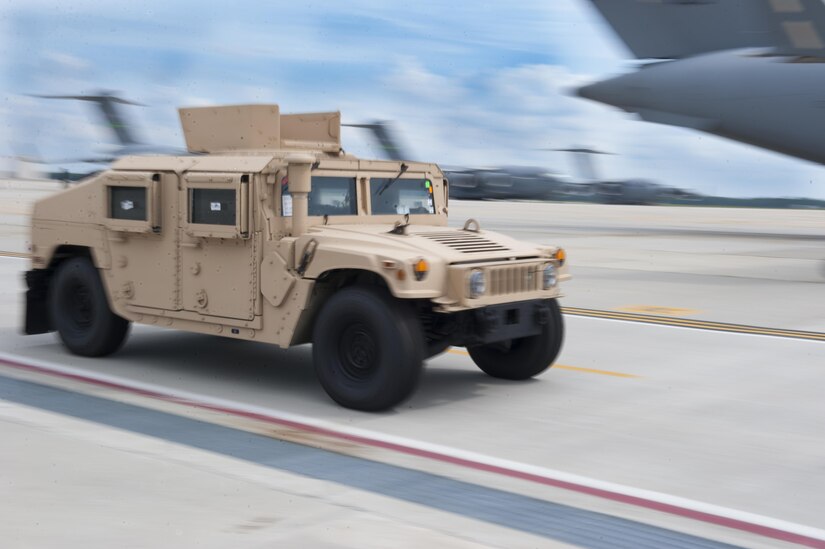 A member of the 305th Aerial Port Squadron drives a Humvee along the flight line on Joint Base McGuire-Dix-Lakehurst, N.J., July 18, 2016. The “Can Do APS” is transporting 50 mission essential Humvees to Iraq this week in support of Operation Inherent Resolve. 