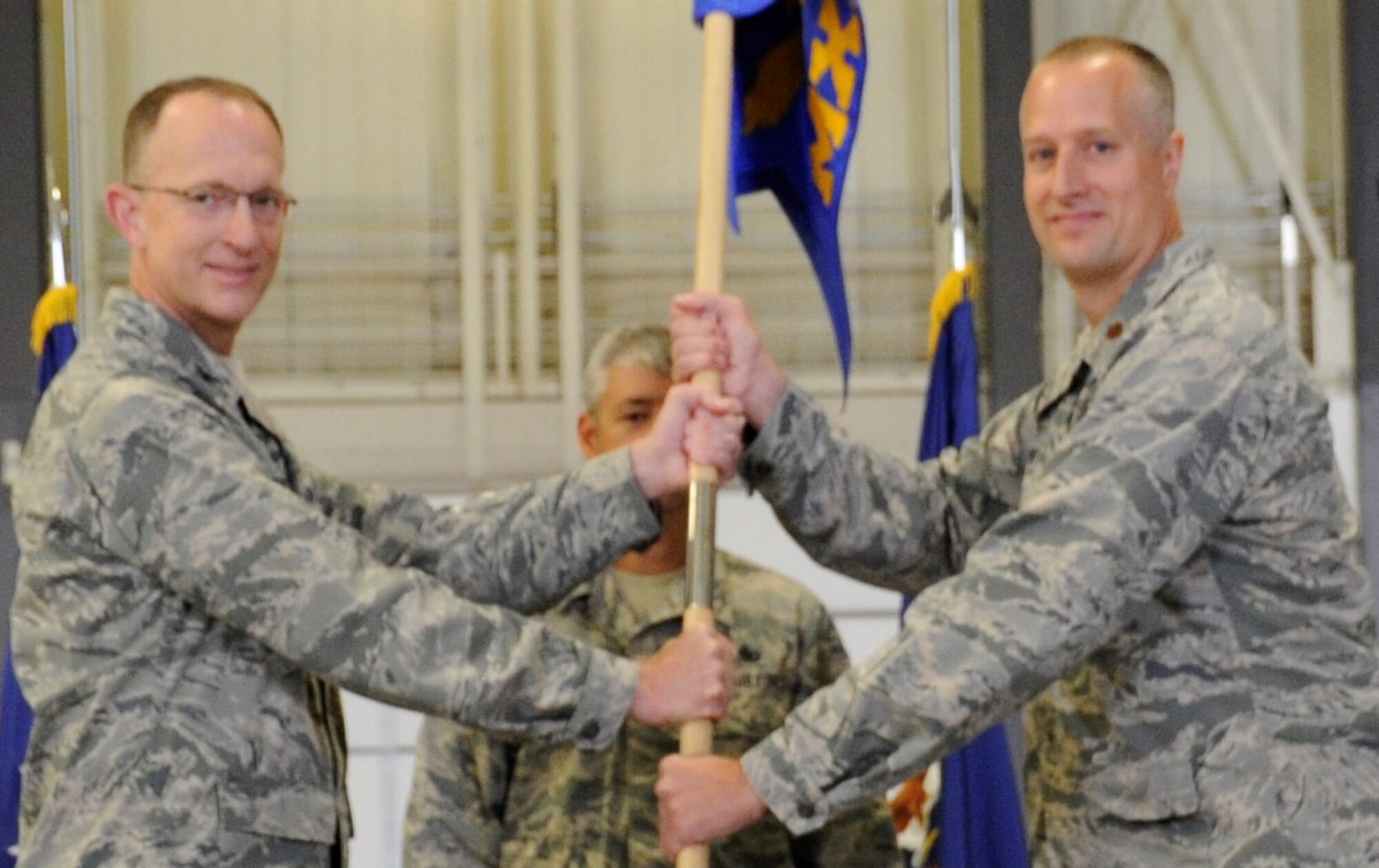PETERSON AIR FORCE BASE, Colo. – Col. Jeffrey Higgins, 302nd Maintenance Group commander, passes the guidon to Maj. Michael Loney as he assumes command of the 302nd Maintenance Squadron in a ceremony July 16, 2016 here. During the ceremony Higgins lauded the squadron’s performance during their recent Southwest Asia deployment and predicted Loney will be an “outstanding commander, ready to take charge of a great organization and make it better.” Loney thanked those that helped make the day happen, saying, “I am humbled with the confidence placed in me to lead this outstanding organization. I look forward to serving with you and alongside you as your partner as we conquer the challenges ahead.” (U.S. Air Force photo/Capt. Cait Suttie)