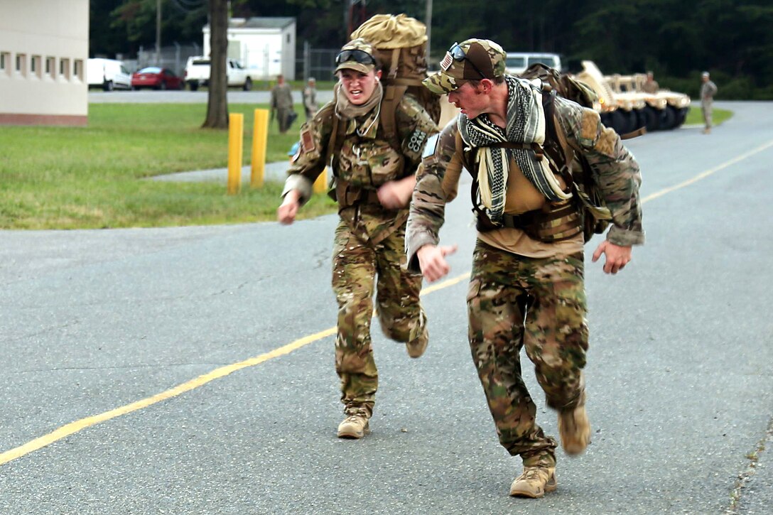 Air Force Staff Sgts. Laura Beckley, left, and Staff Sgt. Samuel Weaver participate in an 8-mile ruck march event during the Fourth Annual Spc. Hilda I. Clayton Best Combat Camera Competition at Fort A.P. Hill, Va., July 12, 2016. Beckley and Weaver are assigned to the 1st Combat Camera Squadron. The ruck march consists of all competitors completing the event with a 35-pound rucksack in a three-hour time limit. Army Photo by Spc. Hayley Gardner