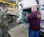 Army Brig. Gen. John Laskodi, DLA Distribution commander, discusses the importance of the preservation process for all incoming and outgoing vehicles and artillery with Marcus Woods, DLA Distribution Anniston, Ala., Vehicles and Artillery Division supervisor.  