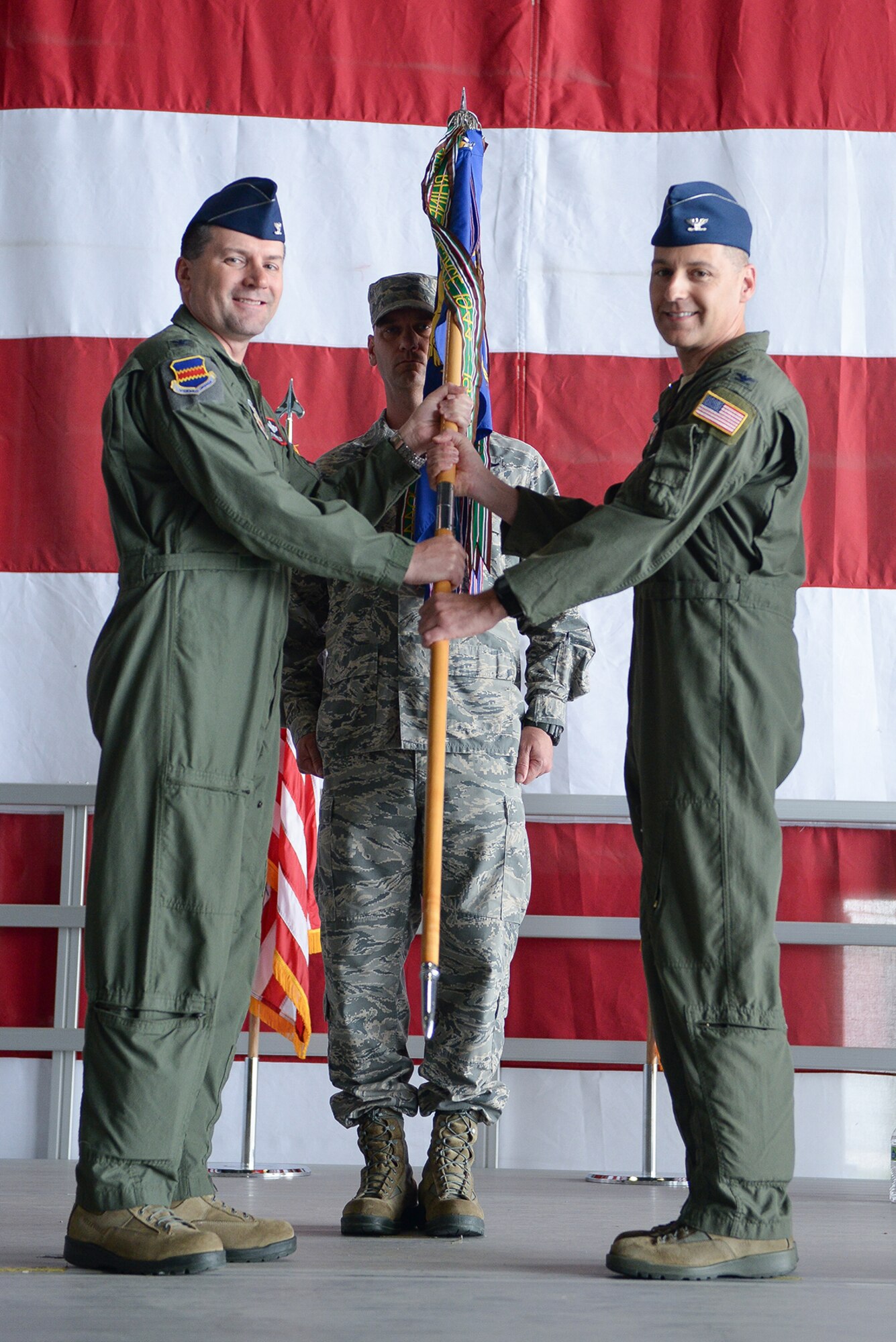 Col. Marty Reynolds (left) hands the 55th Operations Group guidon to Col. Joseph Santucci as part of the 55th OG change of command ceremony July 15 at Offutt Air Force Base, Neb. (U.S. Air Force photo by Zachary Hada/released)