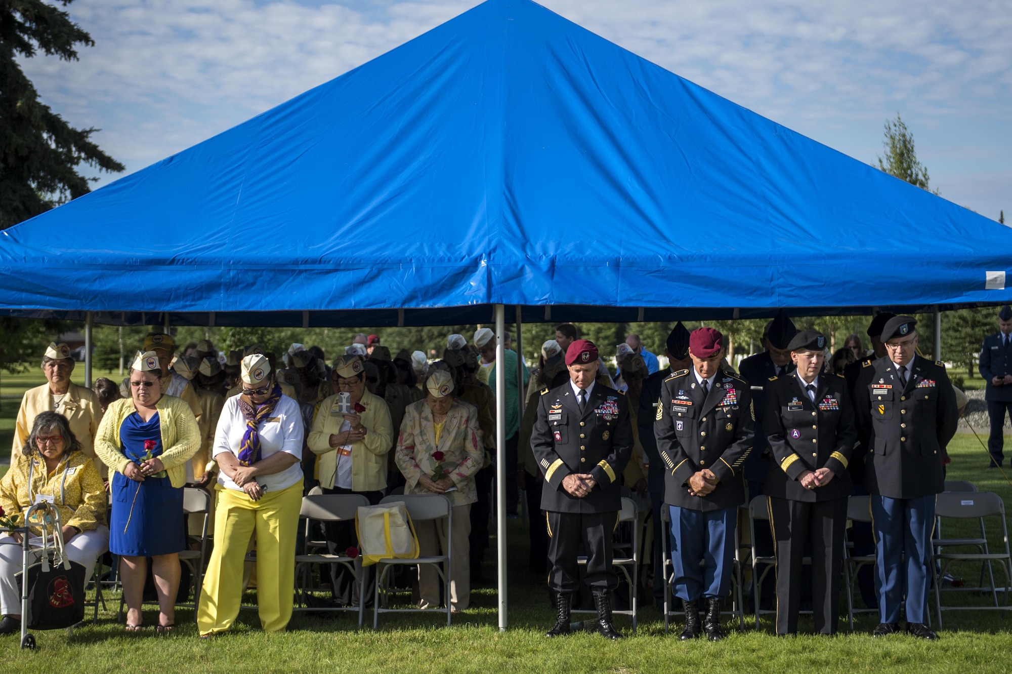 Leadership from Joint Base Elmendorf-Richardson bow their heads in prayer with Gold Star Wives during a memorial ceremony at the Fort Richardson National Cemetery, July 15, 2016 on Joint Base Elmendorf-Richardson, Alaska.  The memorial ceremony was a part of the Gold Star Wives of America's 71st National Convention hosted this year in Anchorage, Alaska.
